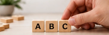 Hand arranging wooden letter tiles